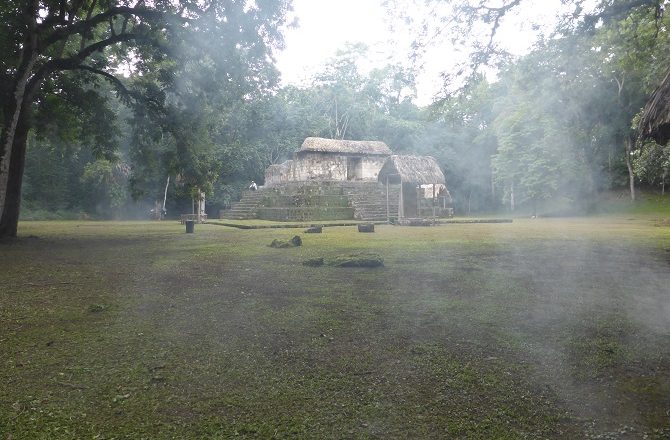 The Mayan ruins at Ceibal with the smoke of natural mosquito repellent
